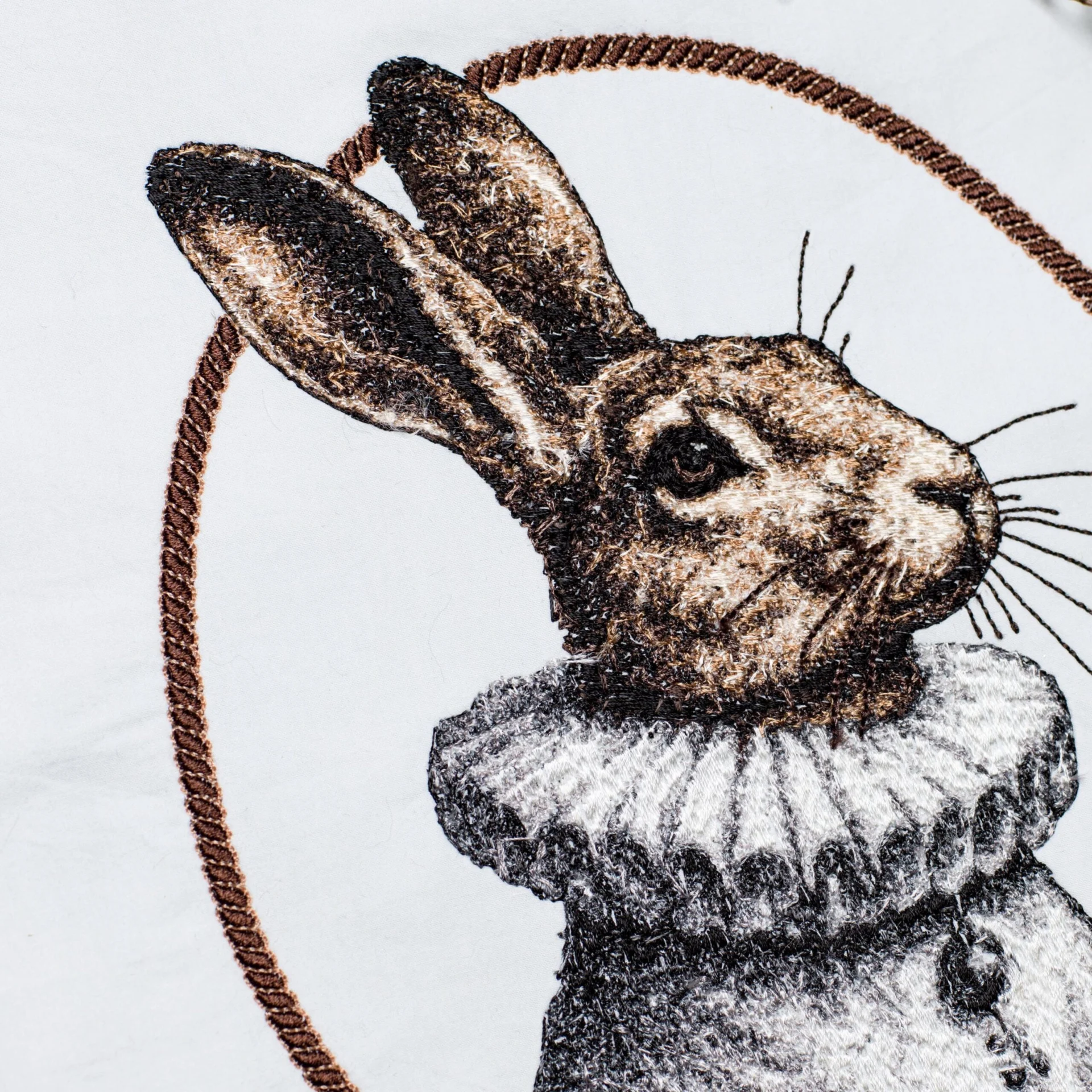 A close-up of a high-quality machine embroidery design showcasing a rabbit in a ruffled collar. The precise stitching highlights intricate shading, realistic fur texture, and crisp details, ensuring a professional and elegant stitch-out.